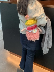 Close-up of handmade crochet crossbody bag featuring a cute cartoon doll design for kids