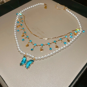 Elegant layered necklace with blue crystal butterfly pendant and white pearls
