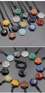 Macro view of natural crystal hexagonal star pendants with woven cords on gray background