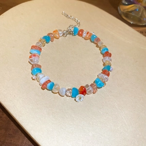Close-up of colorful crystal bead bracelet with a white flower charm and silver clasp