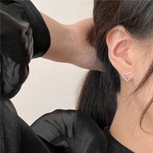 Elegant 925 sterling silver heart stud earrings worn by a model in a minimalist style