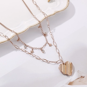 Vue détaillée du collier double épaisseur en acier rose doré avec pendentifs cœur et étoile
