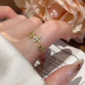 Detail of 18k gold plated floral star ring with cubic zirconia worn on a finger