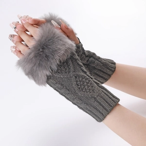 Close-up of gray knitted fingerless gloves with plush faux fur trim on the wrist cuffs