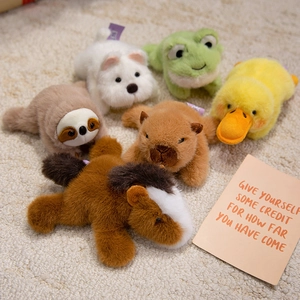 Plush animal magnets set including capybara, sloth, and duck on a soft white rug