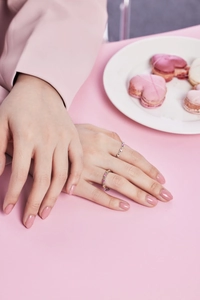 Close-up of stacked S925 sterling silver rings with colorful zircon on a pink table