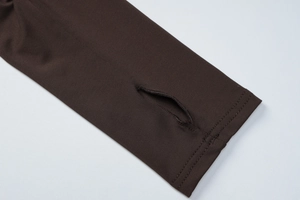 Dettaglio delle maniche lunghe in maglia marrone scuro con polsini con foro per pollice