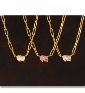 Detail of PVD electroplated gold paperclip chain with heart and rectangle zircon charms