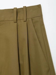 Detailed macro view of khaki utility shorts waist featuring belt loops and front pleats