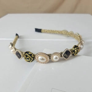 Detail of baroque pearl headband with gold wire and dark grey gemstones for women