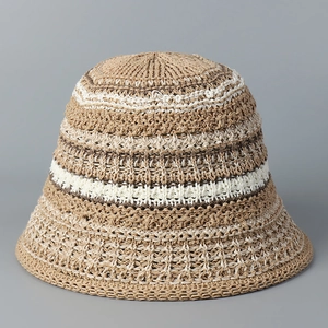 Detailed knit texture of striped hollow straw bucket hat in beige and brown tones