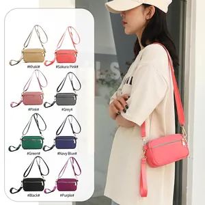 Compact multi-compartment nylon crossbody bag with adjustable strap available in 8 colors