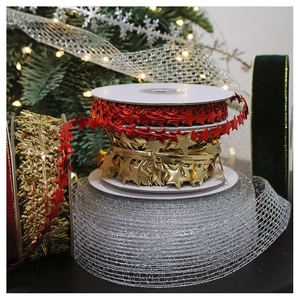 Detail view of festive red and gold star metallic ribbons on rolls for Christmas DIY crafts