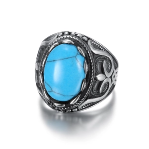 Vintage oval turquoise ring with engraved silver metal band on a clean white background