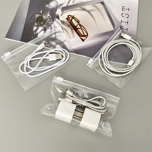 Close-up of portable transparent PVC cable organizers with white charging cables and plugs