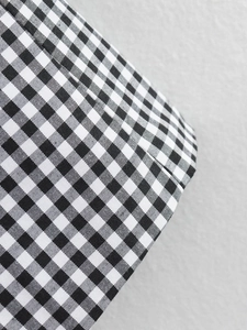 Close-up of black and white checkered woven fabric texture on a modern blazer jacket