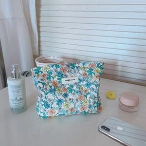 Dettaglio della piccola borsa per trucco in cotone a fiori con etichetta tessuta semplice