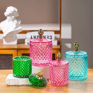 Detail of colorful diamond-patterned glass candy jars with elegant golden crown lids