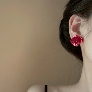 Close-up of a model wearing a vibrant red 3D rose flower stud earring in a resin finish