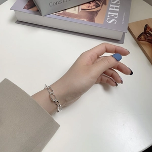 Detail of S925 sterling silver long link chain bracelet worn on a woman's wrist