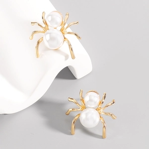 Detail of vintage spider earrings with white pearls and a gold metallic framework