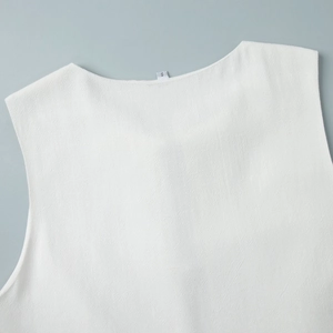 Close-up of white crew neck sleeveless top fabric texture and size S label detail