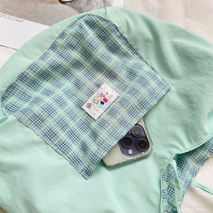 Detail of mint green canvas tote bag with plaid inner pocket and lucky day cloth label