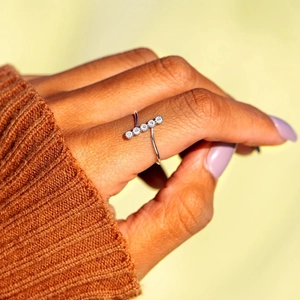 Detail of S925 sterling silver T-shaped ring with five sparkling round zircons on finger