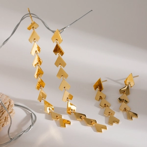 Dettaglio di orecchini a spiga di grano in oro 18k con lunghi ciondoli asimmetrici