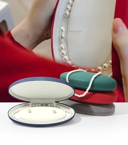 Detail view of oval velvet jewelry boxes for pearl necklaces and earrings in multiple colors