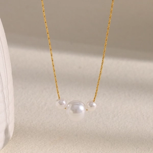 Macro view of 18K gold-plated chain featuring a symmetric trio of lustrous pearls