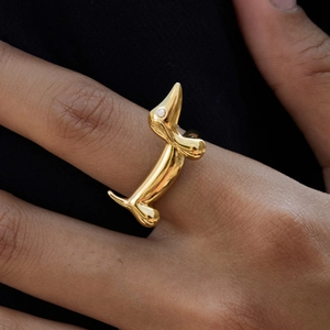 Macro shot of a golden dachshund dog ring with a sparkling stone eye on a finger