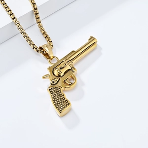 Macro shot of gold stainless steel revolver pistol pendant with detailed cuban link chain