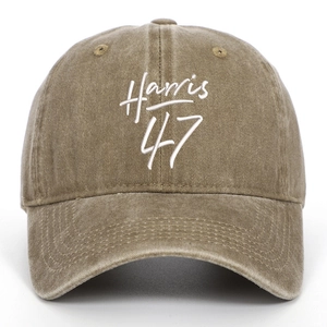 Close-up of olive green washed cotton baseball cap featuring white Harris 47 embroidery
