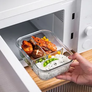Three-compartment heat-resistant glass lunch box being placed in a microwave oven