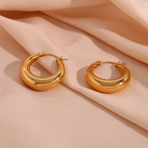 Macro detail of 25mm 18K gold plated chunky hollow hoop earrings on pink satin silk fabric