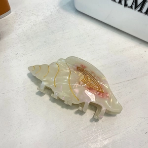 Conch shell acetate hair claw clip with pearl finish and gold accents for women