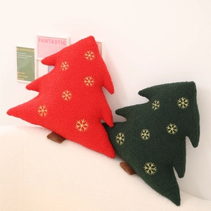 Christmas tree shaped plush pillows in red and dark green with golden snowflake embroidery