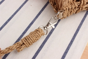 Detail of silver metal lobster clasp and hand-woven texture on the paper straw bag