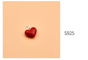 Detail of red heart pendant in 925 sterling silver with polished finish and S925 stamp