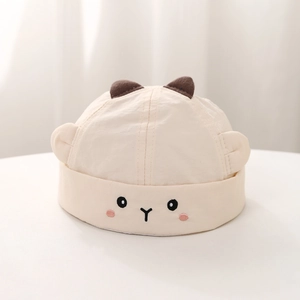 Detailed view of beige cotton baby hat featuring cute animal ears and face embroidery