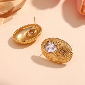 Macro shot of 18K gold plated oval stud earrings with texture and white zircon stone