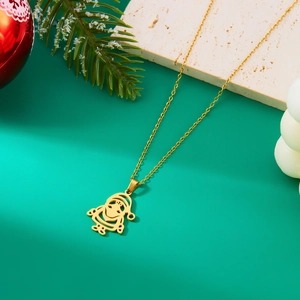 Detailed view of a gold Santa Claus pendant with pine branches and holiday ornaments