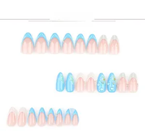 Detail of 3D shell and water drop press-on nails with blue French tips and floral patterns