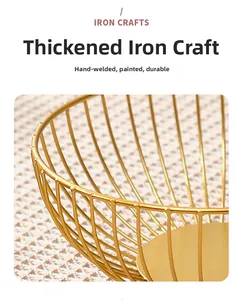Detail showing the thick golden iron wires and manual welding craftsmanship of the fruit basket