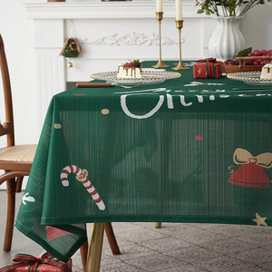 Detail of green Christmas tablecloth with Merry Christmas print and festive decorations