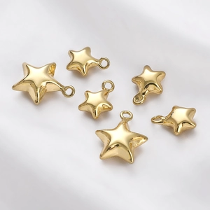 Detailed view of 14K gold plated star charms on white silk for DIY jewelry making