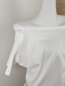 Detail of white off-shoulder t-shirt neckline showing elastic cotton fabric and stitching