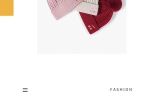 Detail of cable knit beanies with faux fur pom pom and cherry embroidery accents