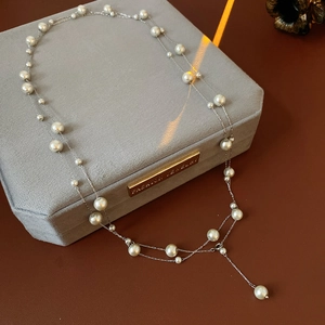Detail of double-layer pearl Y-necklace with silver chain on velvet jewelry box